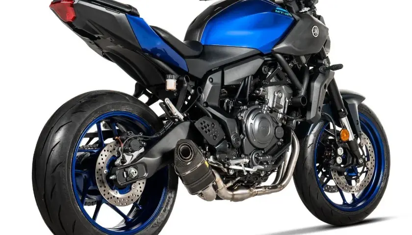 Yamaha MT-07 z wydechem Akrapovič, błyszczący niebieski zbiornik paliwa i czarne detale.