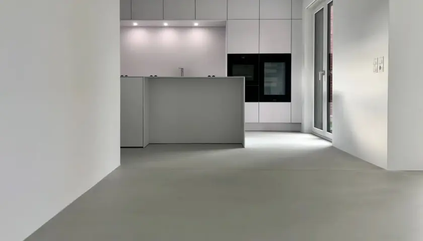 Moderne Küche mit minimalistischer Insel und Einbaugeräten. Der fugenlose Boden erfahrungen sind positiv, da er leicht zu reinigen ist und einen eleganten Look bietet.