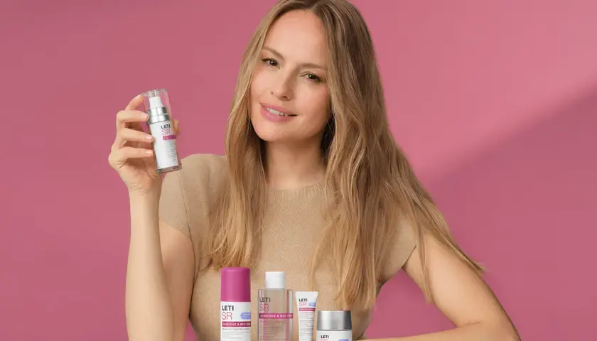 Mujer sonriente con productos Leti SR, ideales para el cuidado de la piel sensible.
