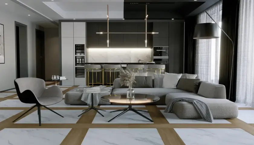 Soggiorno moderno con pavimenti interni che combinano marmo e legno, tra le ultime tendenze. Divano grigio, poltrona, tavolini e cucina a vista.