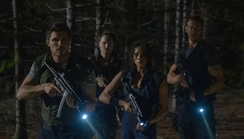 Quattro personaggi armati e con torce si muovono cauti nel bosco, pronti ad affrontare pericoli. Resident Evil: Welcome to Raccoon City recensioni.