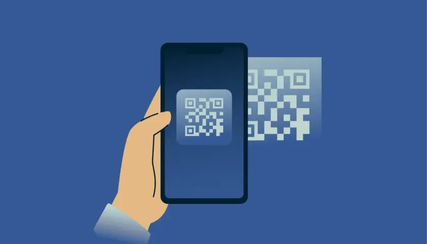 Dłoń trzyma smartfon, na ekranie którego widnieje kod QR. Obok, w tle, kolejny kod QR. Skanowanie telefonu antywirusem online.