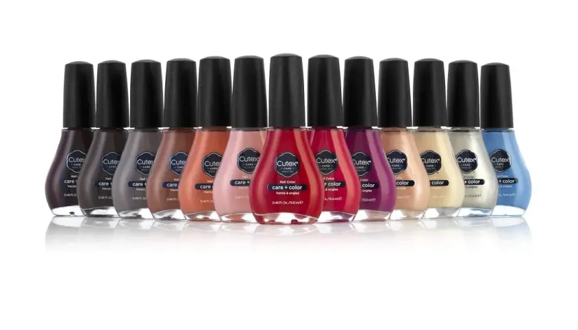 En rad med flaskor med Cutex nagellack i olika färger, från mörkt lila till ljusblått.