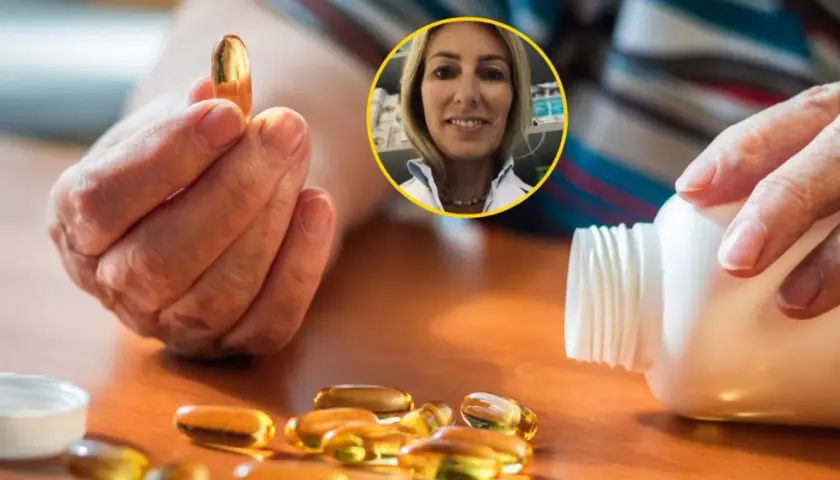 Dłoń trzyma kapsułkę witaminy D. Obok leży buteleczka i kilka kapsułek. W tle uśmiechnięta farmaceutka. Dowiedz się, z czym nie łączyć witaminy D.