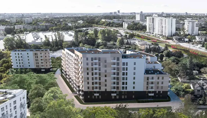 Nowoczesne bloki mieszkalne otoczone zielenią, w tle miejski krajobraz Poznania.