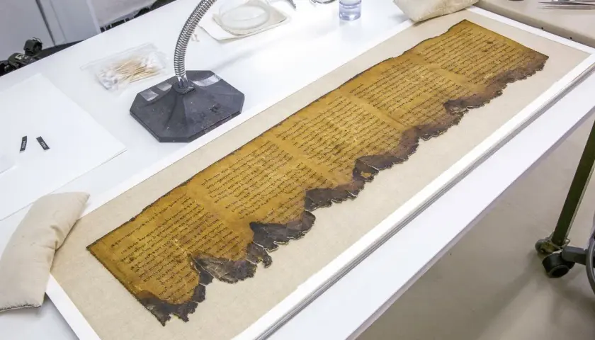 Zwoje z Qumran, starożytne manuskrypty, leżą na stole laboratoryjnym, gotowe do badań.