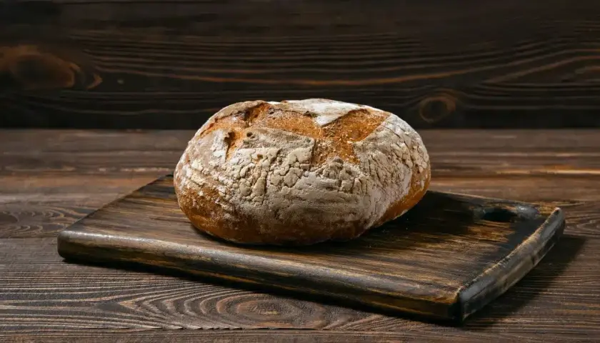 Chleb bezglutenowy na drewnianej desce. Dowiedz się, jak upiec chleb bezglutenowy, by był pyszny i puszysty.