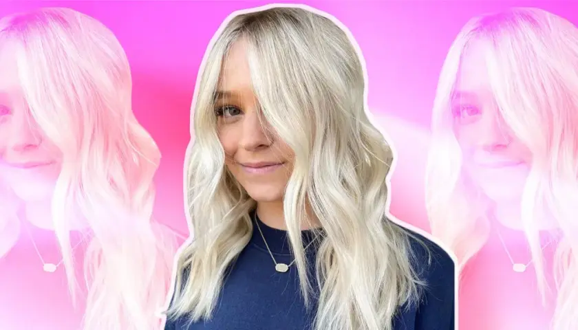 Mujer sonriente con cabello rubio platino, peinado en ondas suaves. Las mechas platinadas resaltan su rostro.
