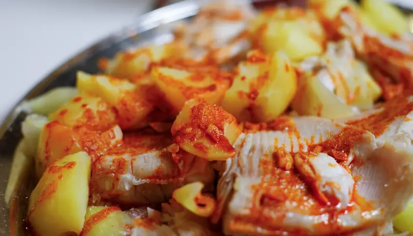 Raya a la gallega, un plato tradicional con trozos de pescado blanco y patatas cocidas, espolvoreado con pimentón.