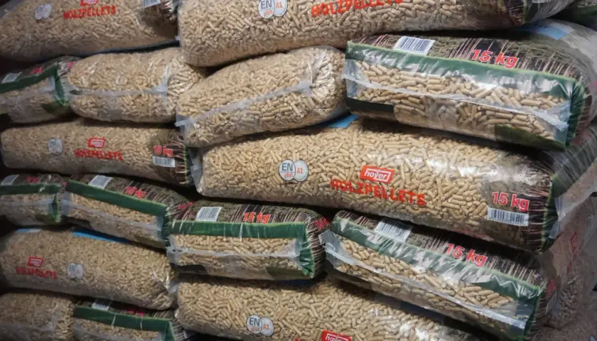 Stos worków z pelletem drzewnym. Na każdym worku widnieje napis "hoyer HOLZPELLET" i waga 15 kg. Ile worków w tonie pelletu?