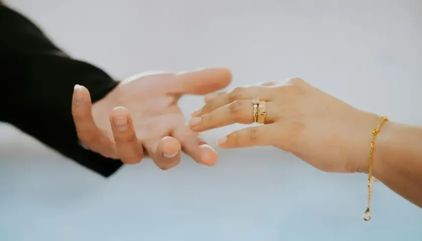 Manos entrelazadas, anillos de oro simbolizan una boda de oro, ¡cuántos años son 50 de amor y compromiso!
