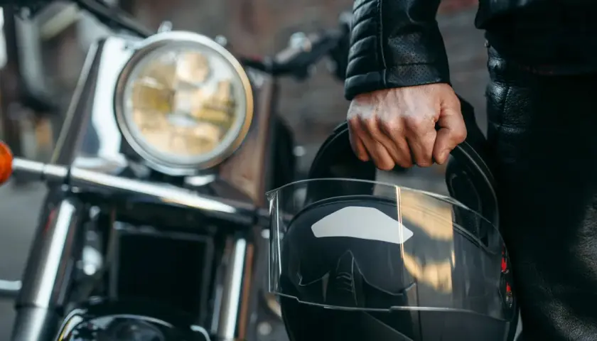 Motociclista con casco negro, listo para aprender como dar de baja una moto.