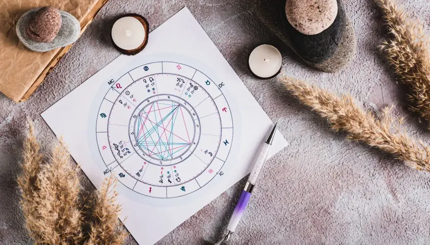 Astrologiczna mapa nieba, świece i pióro. Jak obliczyć ascendent bez godziny urodzenia?