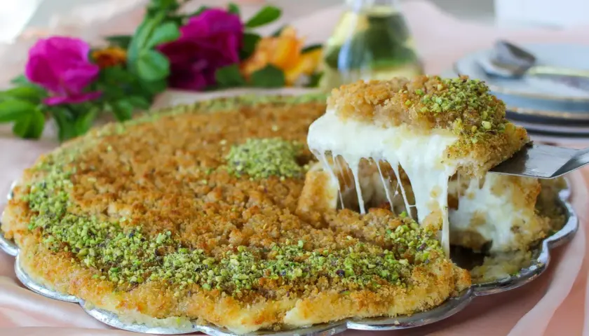 En bit krämig kunafa med smält ost som dras ut, toppad med pistagenötter. Ett läckert kunafa recept att prova!