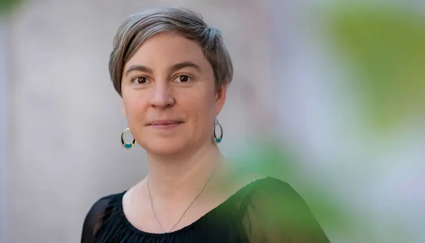 Elin Boardy, med kortklippt grått hår och ovala örhängen, ler mjukt mot kameran.