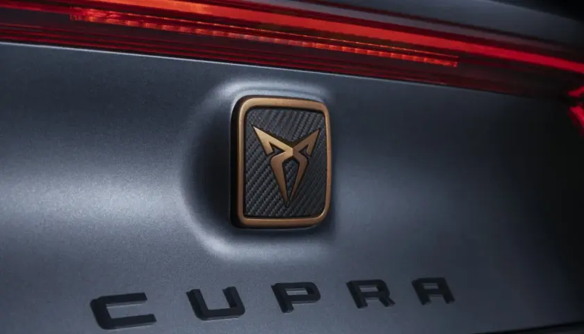 Dettaglio posteriore di un'auto Cupra, con logo in bronzo e carbonio e scritta "CUPRA" in rilievo. Un omaggio al suo **seat origine**.