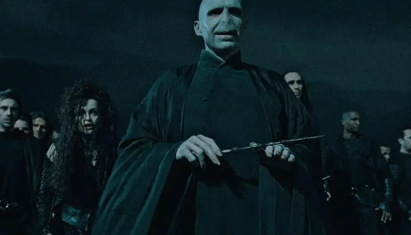 Lord Voldemort, jak miał wyglądać, w otoczeniu śmierciożerców, z różdżką w dłoni.