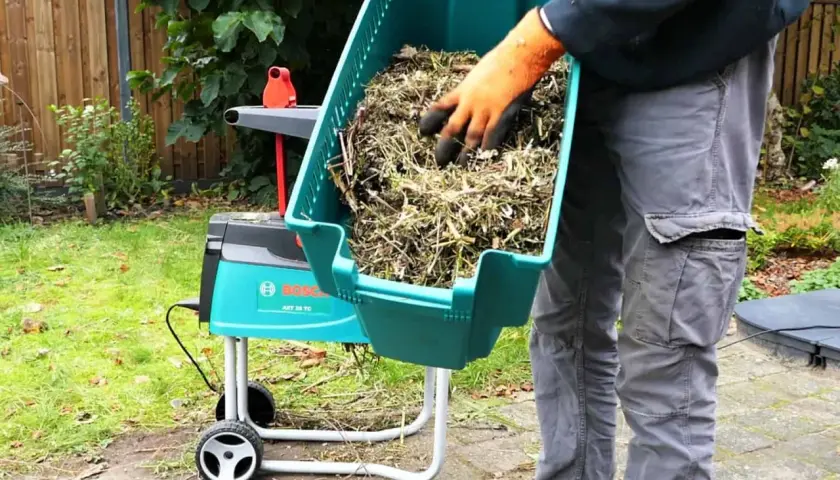 Gartenabfälle werden in den Bosch-Häcksler gefüllt, den **master shredder** für den Garten.