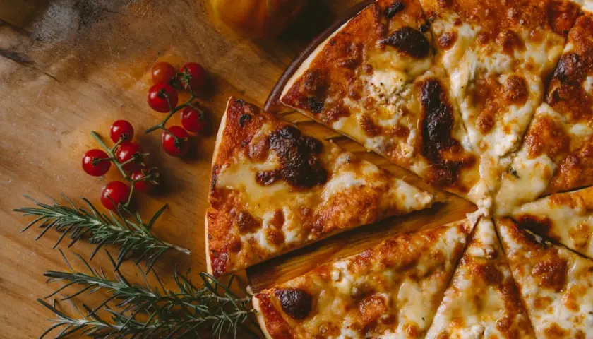 Pyszna pizza z serem i pomidorkami koktajlowymi, idealna do savona menu.