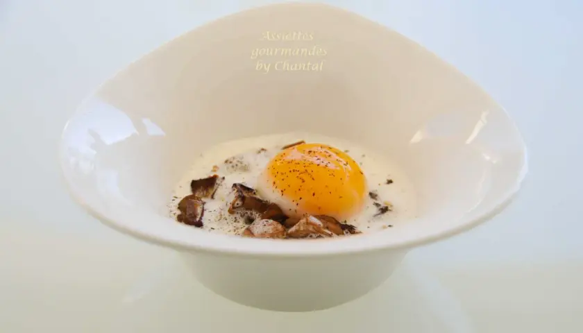 Un œuf parfait, onctueux et doré, baignant dans une sauce crémeuse avec des éclats de champignons. Un délice pour les yeux et les papilles.