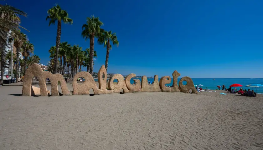 Piaskowy napis "Malagueta" na plaży, palmy i błękitne morze. Czy Malaga ma dostęp do morza? Tak, jak widać!