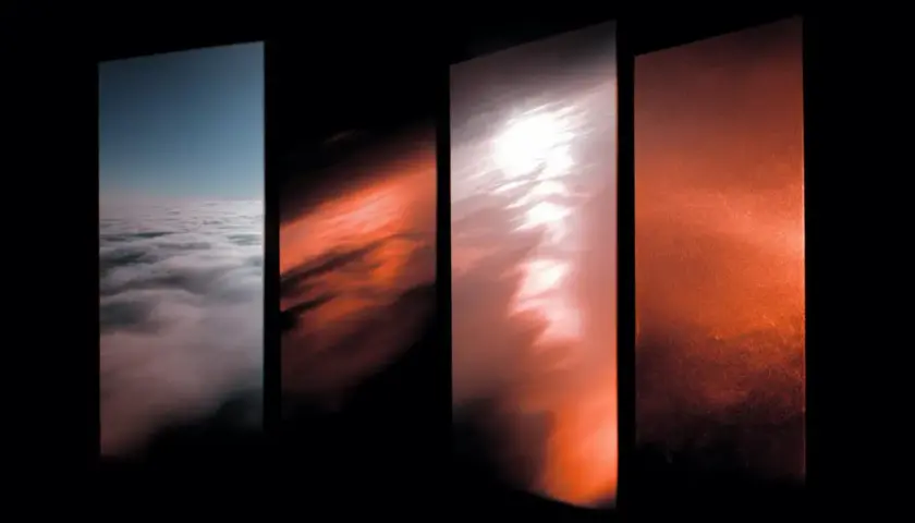 Quattro pannelli verticali mostrano un cielo che sfuma dal blu al giallo e rosso, con nuvole che cambiano colore.