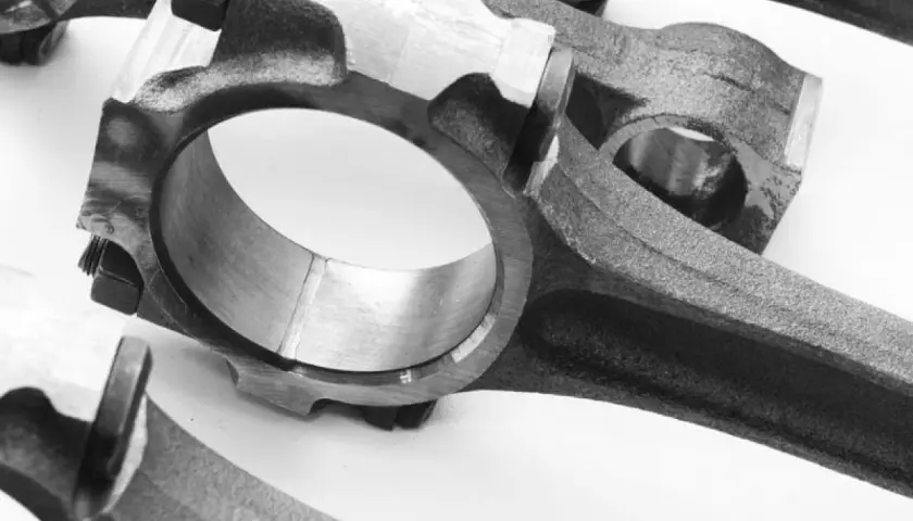 Primer plano de bielas de coche, componentes esenciales que conectan el pistón al cigüeñal, permitiendo el movimiento rotatorio del motor.