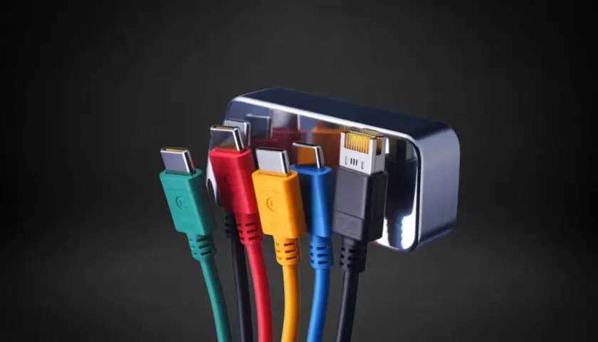 Mehrere bunte Kabel mit USB-C-Steckern und einem Ethernet-Anschluss, die in einen silbernen Adapter gesteckt sind. Ein Display Port Anschluss ist nicht sichtbar.