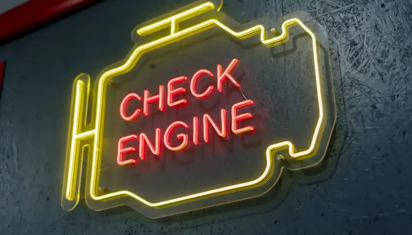 Neonowy napis "CHECK ENGINE" w kształcie silnika. Czy można jeździć z zapalonym "check engine"? To pytanie nurtuje wielu kierowców.