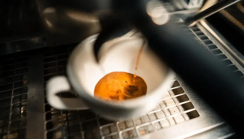 Frisch gebrühter Espresso fließt in eine weiße Tasse. Manche sagen, entkoffeinierter Kaffee sei krebserregend, aber dieser hier sieht köstlich aus.