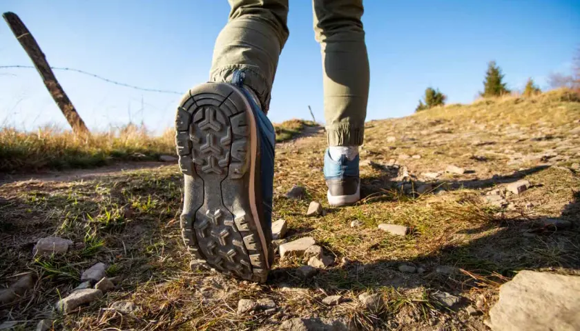 Dobre buty w Tatry to podstawa! Widok na szlak, gdzie stopy w solidnych trekkingowych butach stawiają kolejne kroki.