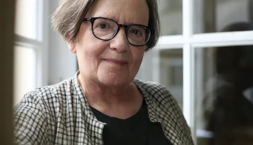 Portret starszej kobiety w okularach, w kratowanej koszuli.