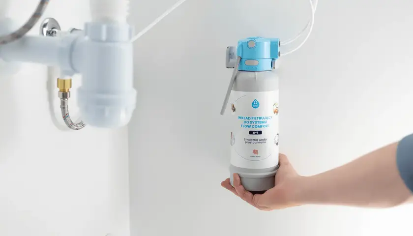 Dłoń trzyma wkład filtrujący do systemu FLOW COMFORT. Czy filtry do wody są zdrowe? Tak, zapewniają smaczną wodę prosto z kranu.