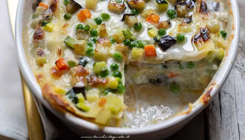 Lasagne alle verdure ricetta della nonna: strati di pasta, besciamella cremosa e un ricco mix di zucchine, carote, melanzane e piselli, gratinate al forno.