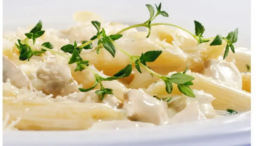 Penne w kremowym sosie z kurczakiem i parmezanem, ozdobione świeżym tymiankiem. Różne rodzaje makaronu mogą być równie pyszne!