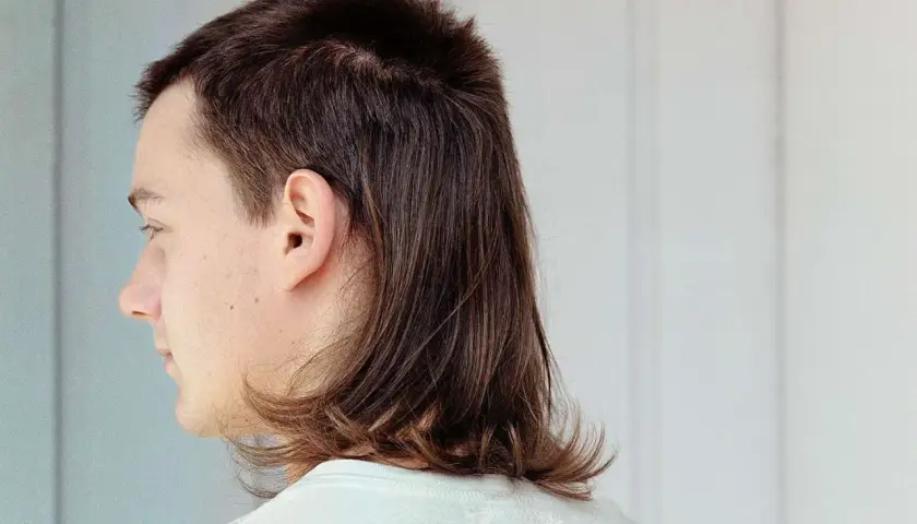 En tjej med en modern mullet frisyr, kortklippt upptill och längre i nacken.