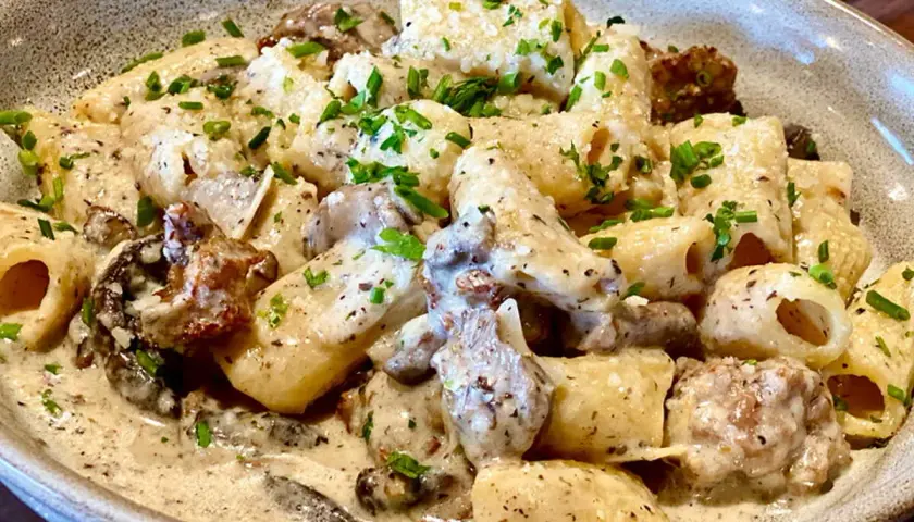 Un plat de pâtes aux champignons, une recette italienne crémeuse et savoureuse, garnie de persil frais.
