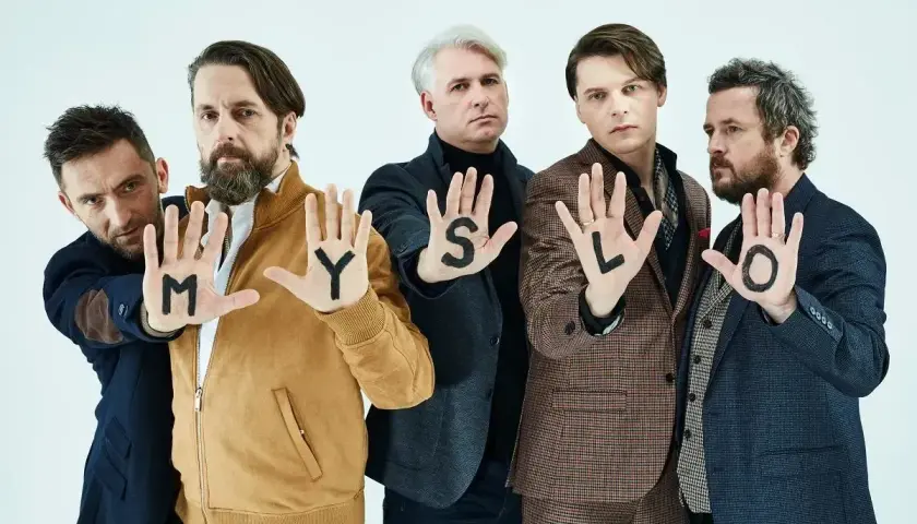 Myslovitz wokalista i zespół pokazują litery na dłoniach: M, Y, S, L, O.