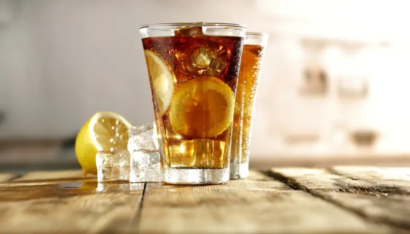 Dwa orzeźwiające long island iced tea z plasterkami cytryny i lodem, gotowe do degustacji.