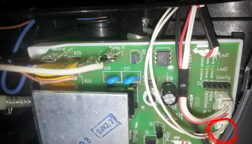 Wnętrze ekspresu Dolce Gusto, gdzie **ekspres Dolce Gusto nie pobiera wody**. Widoczna zielona płytka drukowana z przewodami i elementami elektronicznymi.