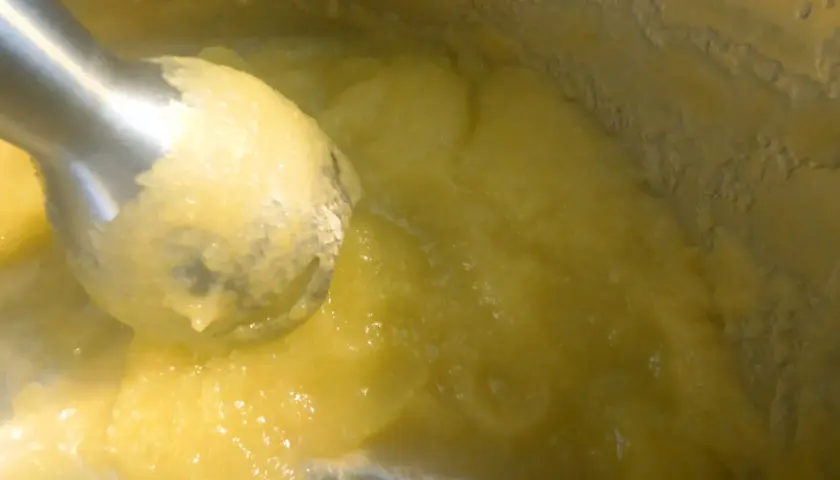 Blendowanie parowanej cukinii na puree dla niemowlaka. Zdrowy, żółty posiłek gotowy do podania.