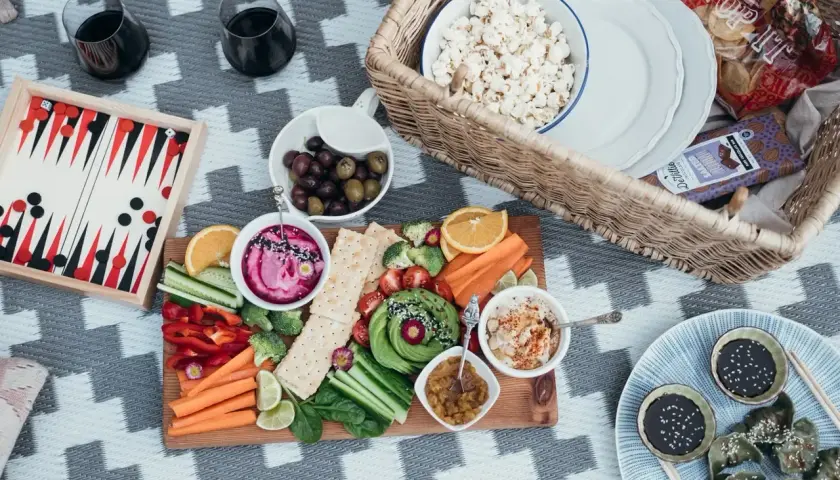 Piknikowy stół z warzywami, dipami i popcornem. Idealna opcja dla weganizmu a wegetarianizmu.