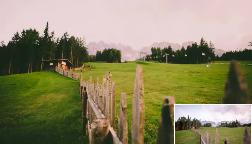 Darmowe presety Lightroom ożywiają krajobraz z drewnianym płotem i chatką w górach.