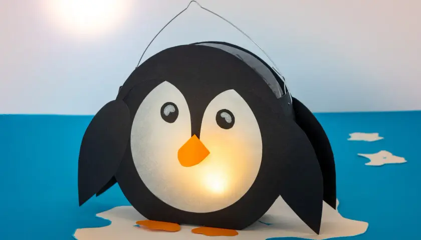 Ein süßer, selbstgebastelter Pinguin als Laterne leuchtet warm. Perfekt zum Basteln für Kinder!
