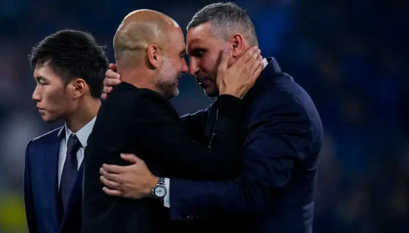 Pep Guardiola i Ryan Giggs w uścisku, symbolizującym szacunek i rywalizację, która wpływa na rankingi Man City.