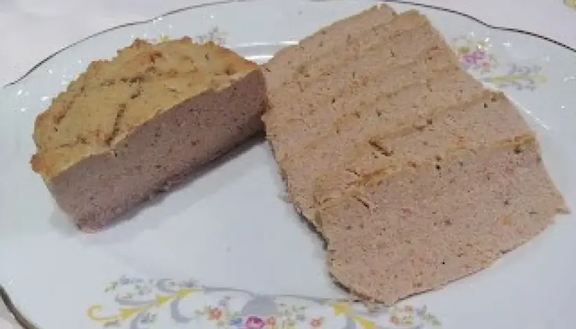 Pokrojony pasztet wieprzowy na talerzu z ozdobnym wzorem.