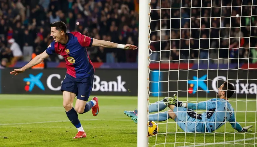 Piłkarz świętuje gola w meczu La Liga, bramkarz leży na ziemi.