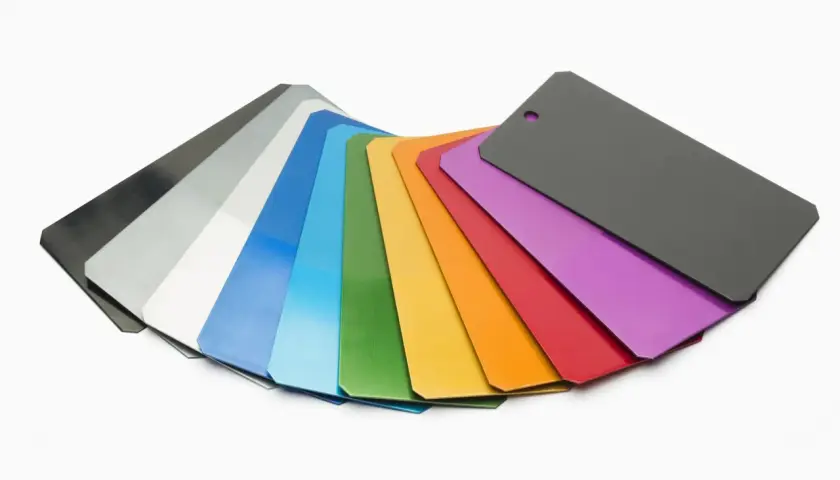 Ventaglio di campioni con diversi colori anodizzazione alluminio: dal nero al grigio, bianco, blu, verde, giallo, arancione, rosso, viola e grigio scuro.