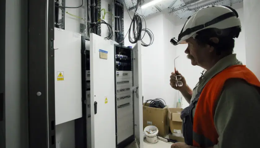 Inżynier elektryk w Niemczech, pracujący przy rozdzielnicy, zastanawia się, ile zarabia.