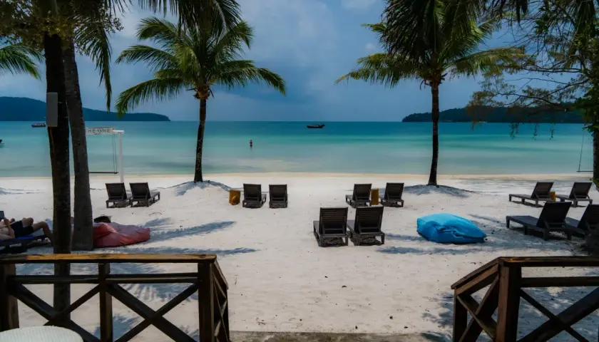 Rajska plaża na Koh Rong, Kambodża. Palmy, leżaki i turkusowa woda zapraszają do relaksu.